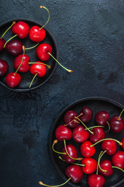 istock Cherry with leaf on plate and water dropsand on grey stone table 1254625382