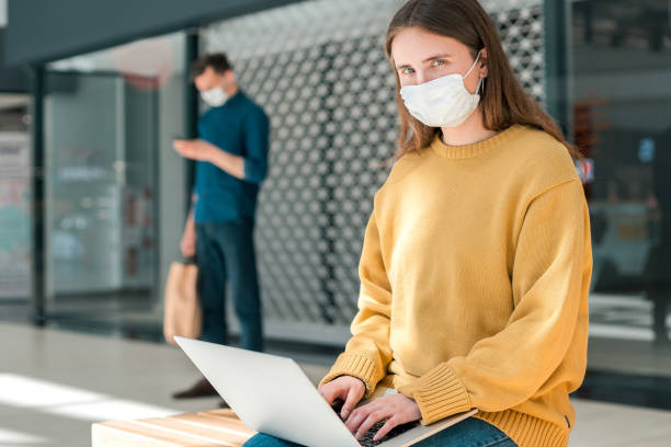 istock female blogger in a protective mask works on a laptop 1254626266
