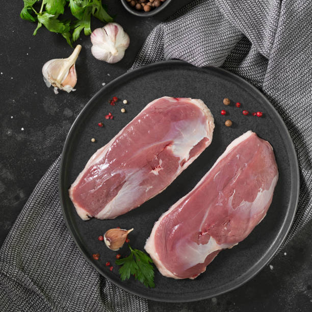 istock Raw duck meat on a black plate. The view from the top 1254626692