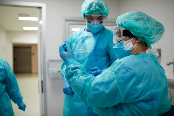 istock An expert healthcare worker supervising how to put on protective worker. 1254627832