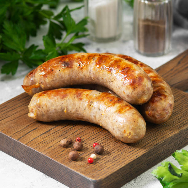 istock Grilled sausages on a wooden Board on a light gray kitchen table 1254629885