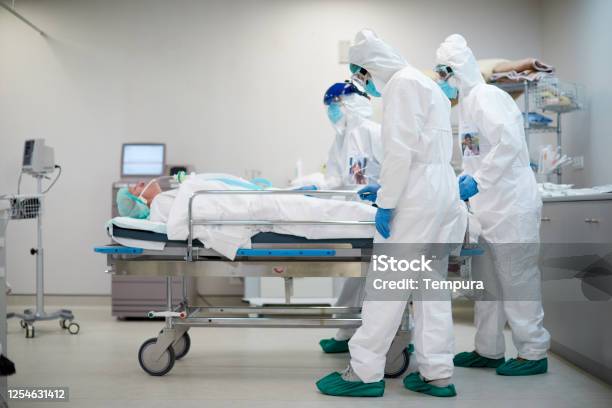 Tired And Sad Healthcare Workers Pushing A Hospital Gurney Stock Photo - Download Image Now
