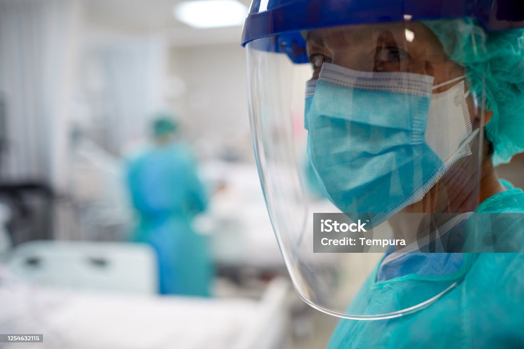 Close up view of a doctor wearing surgical mask and a face shield. Hospital COVID Protective Workwear Stock Photo