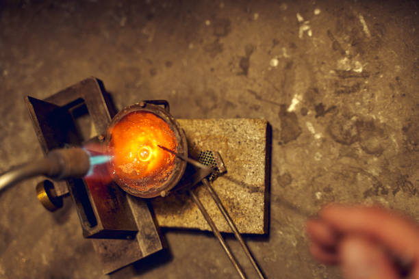 istock Professional goldsmith holding a blowlamp over the crucible 1254632308