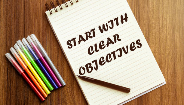 istock START WITH CLEAR OBJECTIVES. your future target searching, a marker, pen, three colored pencils and a notebook for writing 1254633340