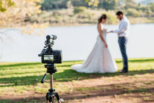 Filming Wedding Online - Social Distancing New Normal Concept Filming Wedding Online - Social Distancing New Normal Concept live streaming - selective focus on the camera eloping stock pictures, royalty-free photos & images