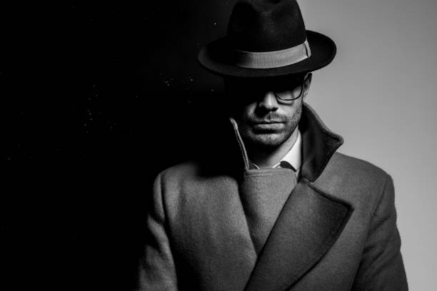 istock mysterious young man in long coat wearing hat and glasses 1254634543