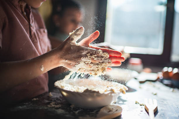 Toddler boy and girl are preparing food in kitchen. Food preparation at home during COVID-19 isolation.