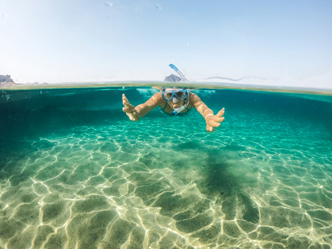 Young caucasian woman snorkeling and having fun in the sea.