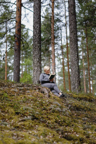istock girl reading a book in the forest 1254639857