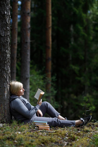 istock girl reading a book in the forest 1254639927