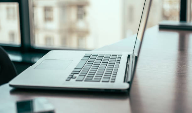 istock side view. open laptop on the office Desk 1254640251