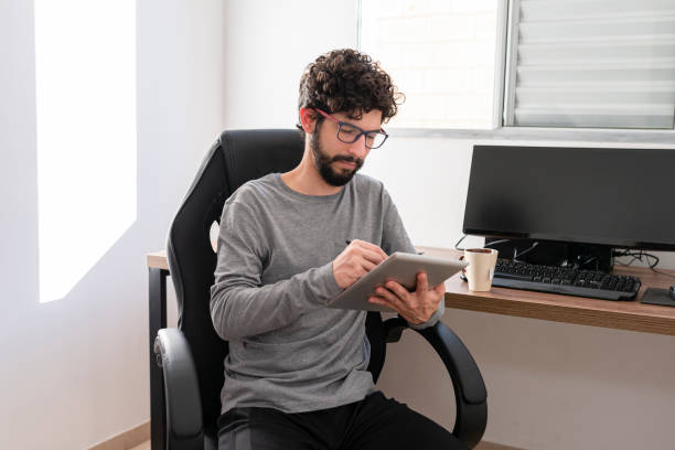 istock Hispanic in his office working with tablet. Home office concept 1254640374