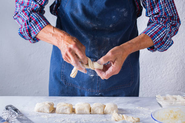 istock Baking at home concept. Senior man hands cooking, making dough 1254640494