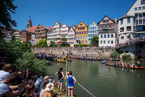 Stocherkahn fest or punt boat festival is an annual traditional boat racing in Tübingen on Neckar river. the rivals are university student and the Photo shows the award giving to winner and people are watching the stage and the show.