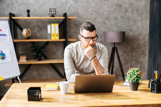 istock Young concentrated guy works with laptop 1254641640