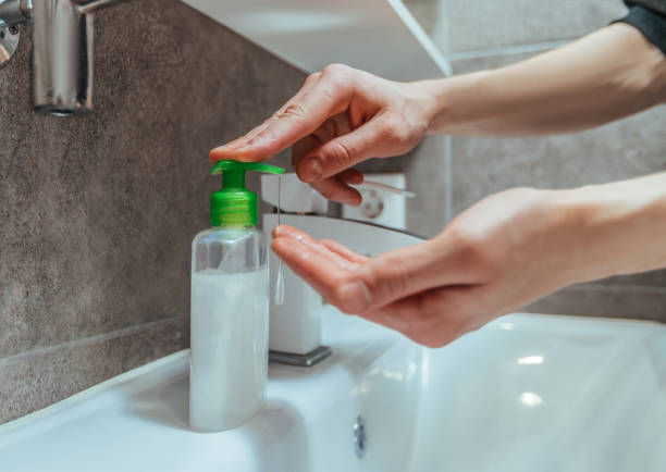 istock close up. modern guy pushing the dispenser with aniseptic gel 1254644250