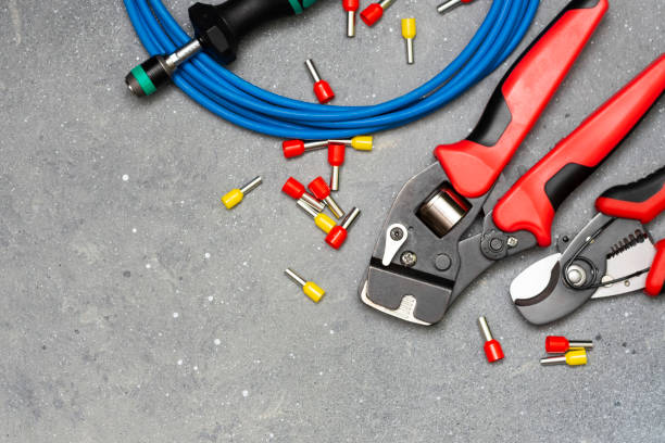 istock Tools and tips of different sizes and colors for crimping stranded electrical wires. Crimping tools, wire tips and electrical cable on a grey concrete background 1254644320