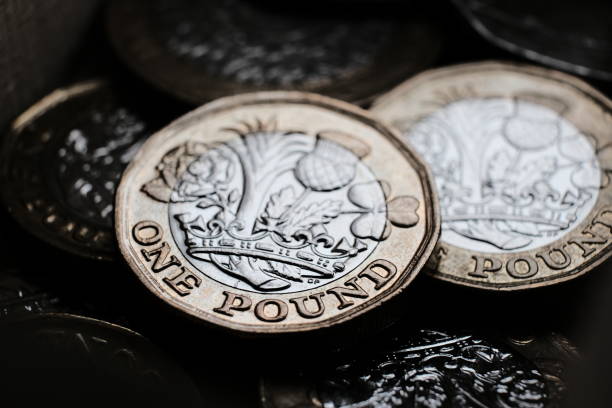 monedas británicas de una libra colocadas una encima de la otra en la caja. las monedas tienen reflejos brillantes y sombras profundas. - british coin coin one pound coin uk fotografías e imágenes de stock