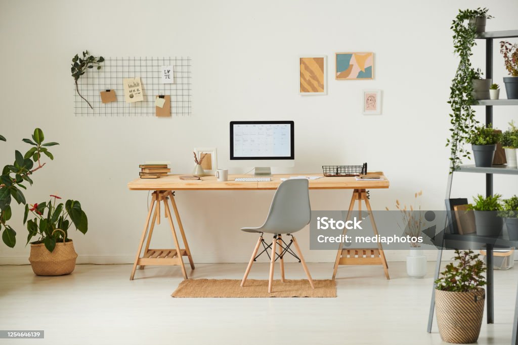 Comfortable workplace with potted plants, wall organizer, pictures and computer Comfortable workplace with potted plants Desk Stock Photo