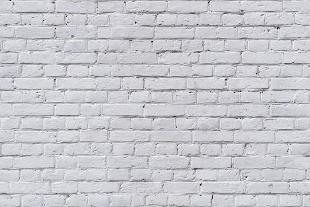 istock Full frame image of the weathered painted white brick wall 1254648913