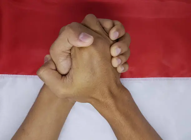 Hands shake on the Indonesian flag, independence day symbol