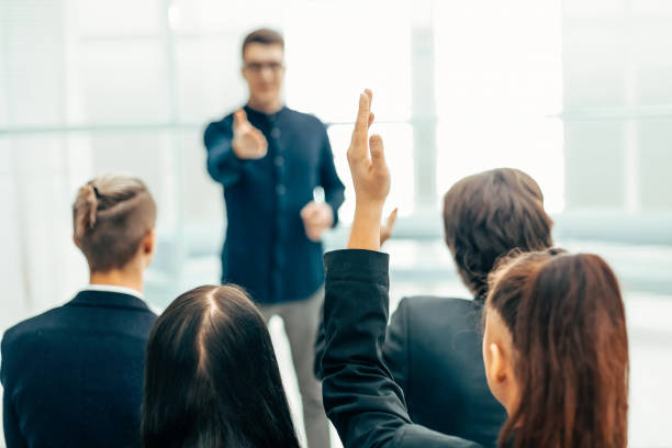 istock rear view. employees ask questions at a business briefing 1254650565