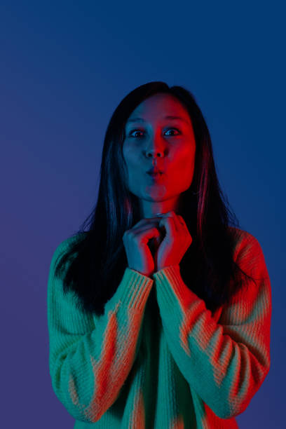 istock Attractive young woman making a grimace lighted in red and blu 1254650606