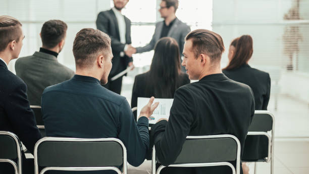 istock back view. group of employees sitting in a conference room 1254650680