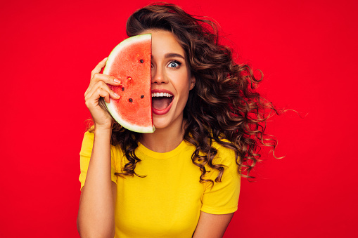 Studio portrait of a beautiful girl with watermelon