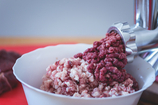 Meat grinder with ground pork and venison, close up