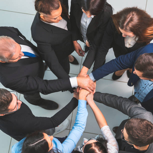 istock top view. boss and business team making a stack of hands 1254656543