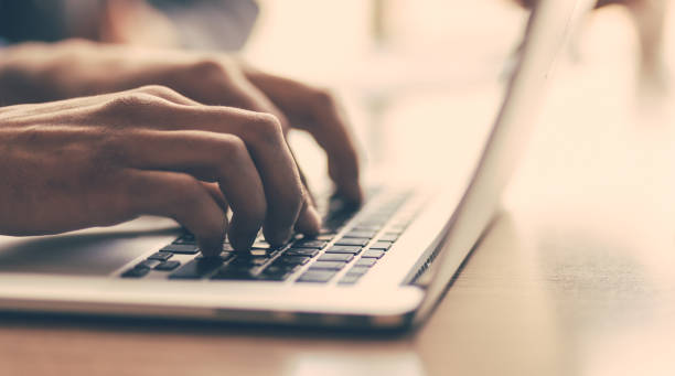 istock close up. a man typing on a laptop 1254657342