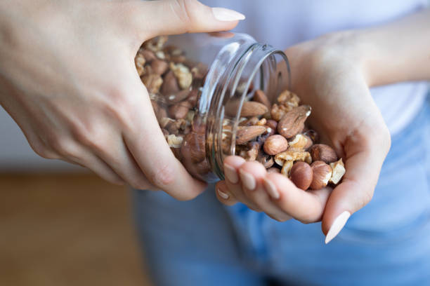 nuts in woman hands - noz imagens e fotografias de stock