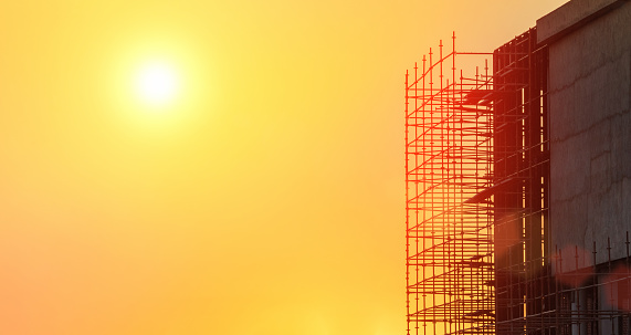 building in construction at sunset with scaffolding on the side