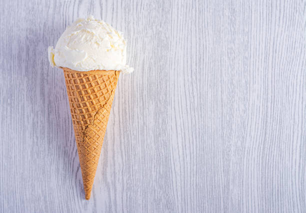 Ice cream cone on a white wood background. A wafer-style ice cream cone.