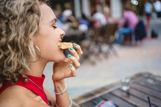 istock Young woman biting a cookie at a cafe 1254674952
