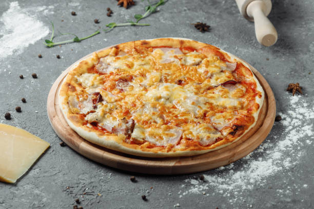 istock pizza with cheese, sauce and ham, bacon, salami on a gray dark background 1254682019