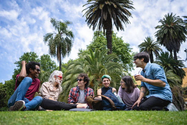 istock Beautiful cheerful students enjoying a sunny day on grass in campus 1254682870