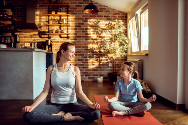 istock Mother and Daughter doing Yoga 1254685341