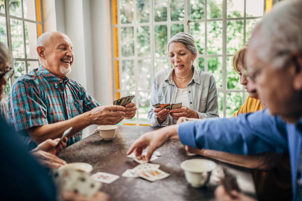 istock Senior friends having fun playing cards 1254697304