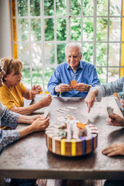 istock Senior friends having fun playing cards 1254697313