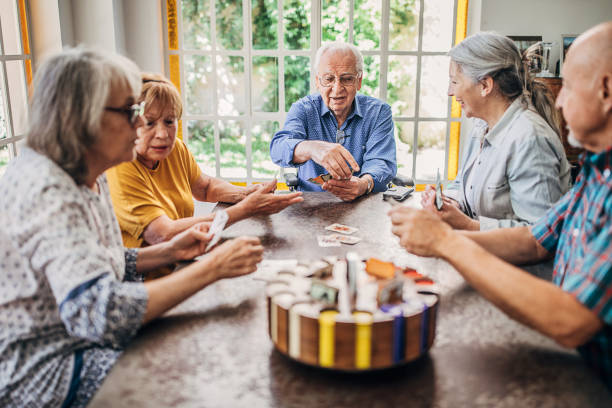 istock Senior friends having fun playing cards 1254697323