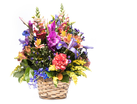 bouquet of bright flowers in basket isolated on white background. Mothers Day or Valentines Day Concept.