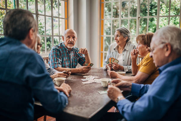 istock Senior friends having fun playing cards 1254698435