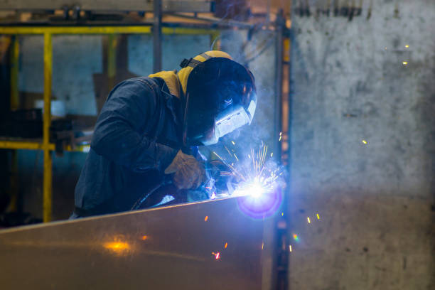 istock Unrecognizable worker at a workshop welding metal pieces wearing protective workwear 1254700740