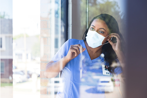 Enfermera se pone la máscara protectora de la cara photo