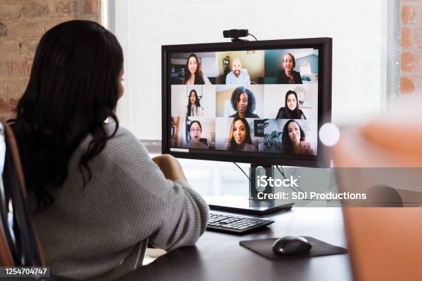 Businesswoman Meets With Colleagues During Virtual Staff Meeting Stock Photo - Download Image Now