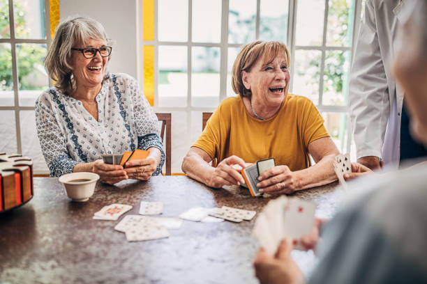 Senior women playing cards and having fun in nursing home Group of people, senor people playing cards in nursing home. friends playing cards stock pictures, royalty-free photos & images