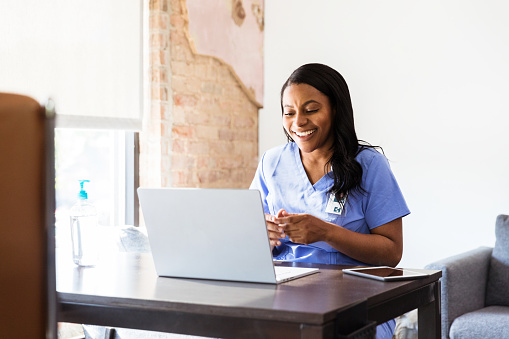 Smiling mid adult female doctor gives good news to a patient during a telemedicine appointment.